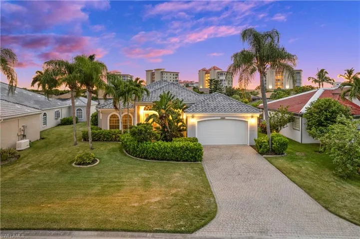 Mediterranean / spanish-style home with a garage and a lawn