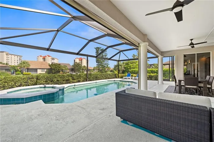 View of pool featuring an in ground hot tub, a lanai, outdoor lounge area, a patio area, and ceiling fan