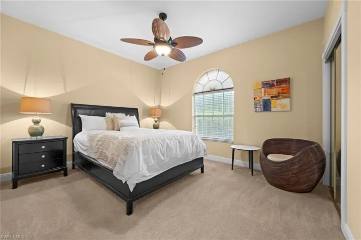Carpeted bedroom featuring ceiling fan