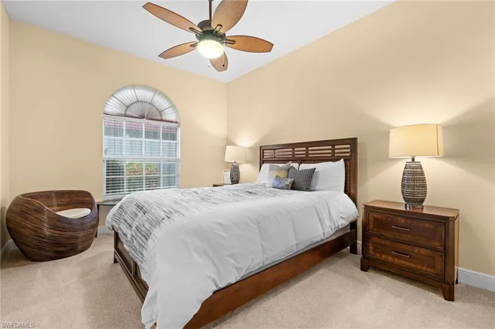 Carpeted bedroom featuring ceiling fan
