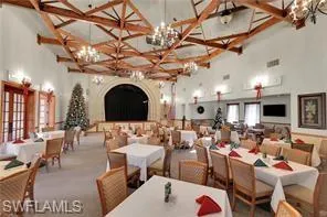 Carpeted dining room with a high ceiling and a chandelier