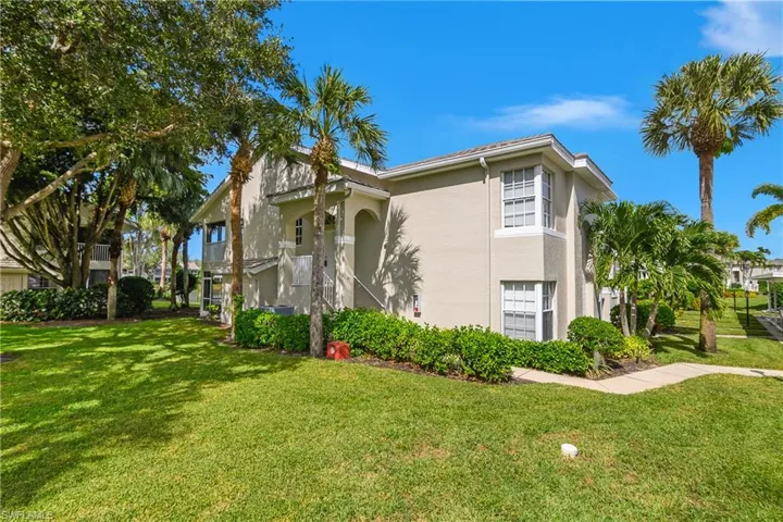 View of side of property with stucco siding and a lawn
