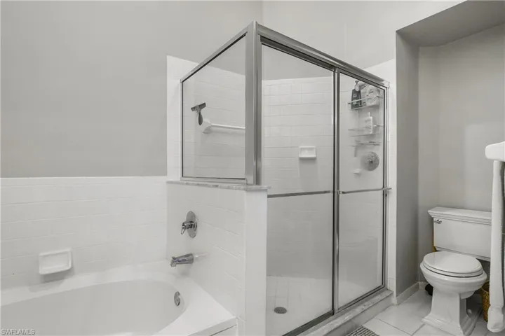 Full bathroom with a bath, light tile patterned flooring, and a shower stall