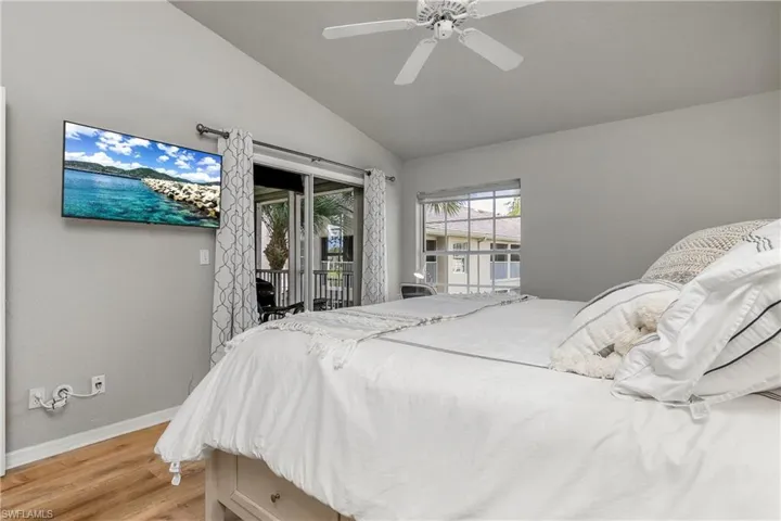 Bedroom with light wood-type flooring, access to outside, lofted ceiling, and ceiling fan