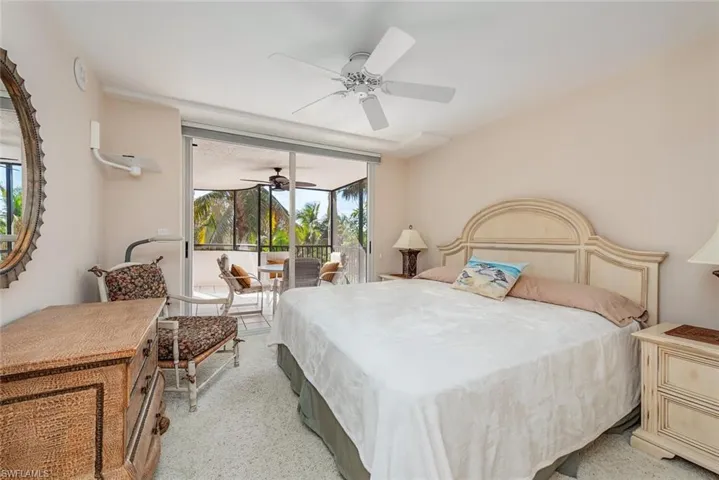 Bedroom with access to exterior, ceiling fan, a sunroom, and light carpet