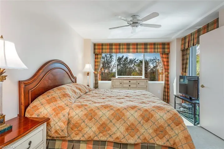 Bedroom with light carpet and a ceiling fan