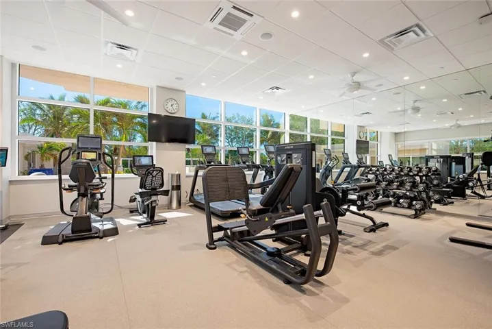 Workout area featuring recessed lighting and a drop ceiling with state of the art equipment overlooking the pool and spa