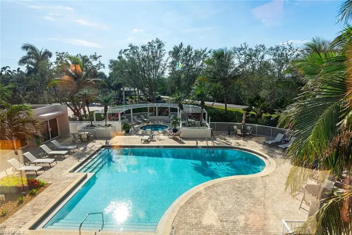 Community pool with a patio and a hot tub