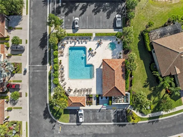 Community swimming pool with an integrated spa, surrounded by lounge seating and a paved sun deck