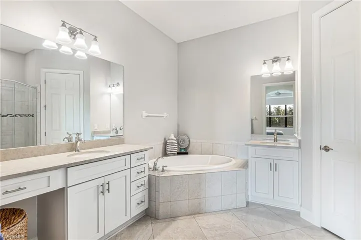Bathroom with two vanities, a bath, and a shower stall