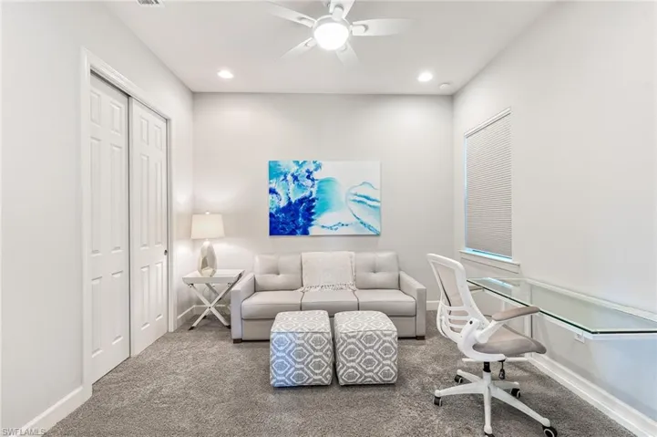 Carpeted office space with a ceiling fan and recessed lighting