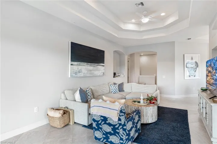 Living room featuring a ceiling fan, arched walkways, recessed lighting, and light tile patterned flooring
