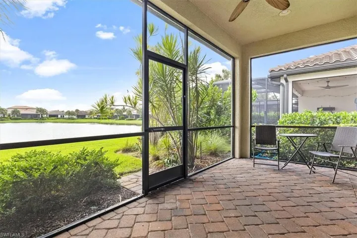 Sunroom / solarium featuring a ceiling fan and a water view