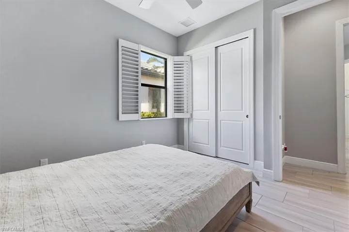 Bedroom featuring a closet, wood finish floors, baseboards, and a ceiling fan