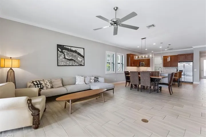 Living area with crown molding, ceiling fan, baseboards, and recessed lighting