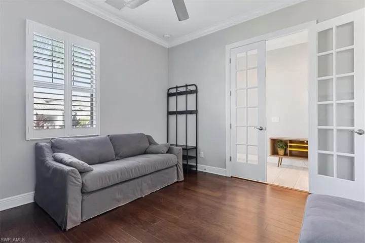 Sitting room featuring crown molding, baseboards, hardwood / wood-style floors, and ceiling fan