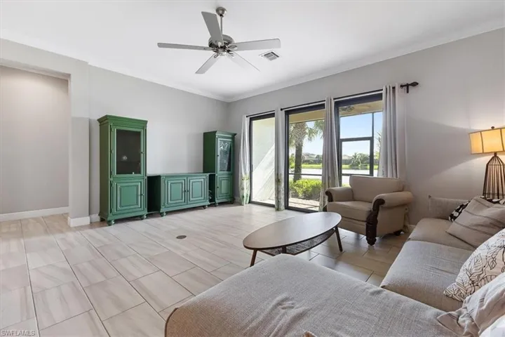 Living room featuring ceiling fan, crown molding, and baseboards