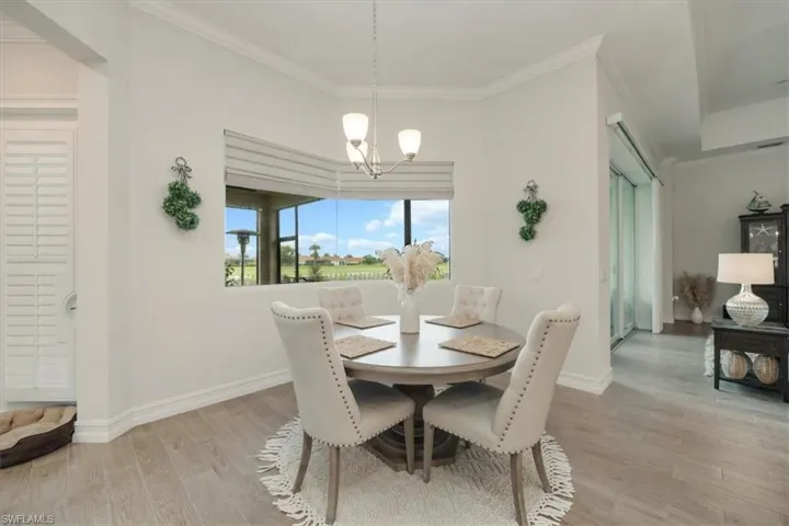 Dining space featuring light wood-style flooring, ornamental molding, and a chandelier