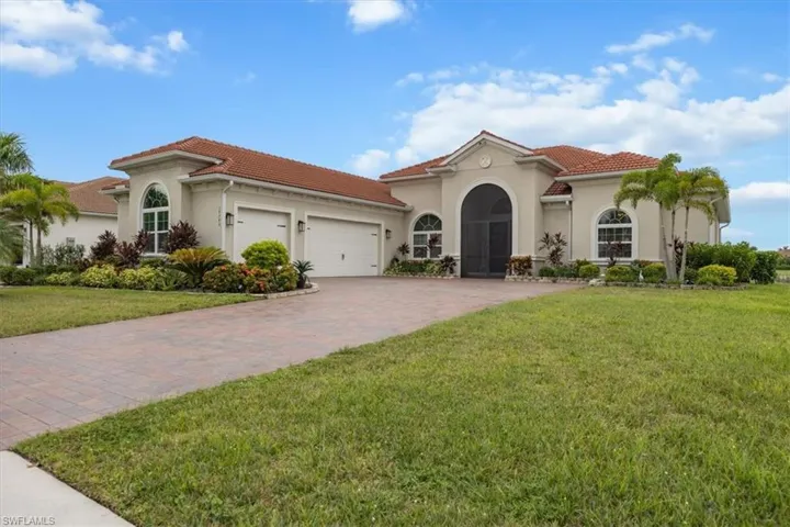 Mediterranean / spanish home featuring stucco siding, an attached garage, a front yard, a tiled roof, and driveway