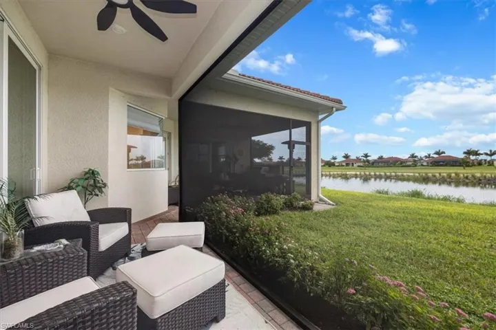 View of patio / terrace featuring a sunroom, a water view, ceiling fan, and an outdoor living space