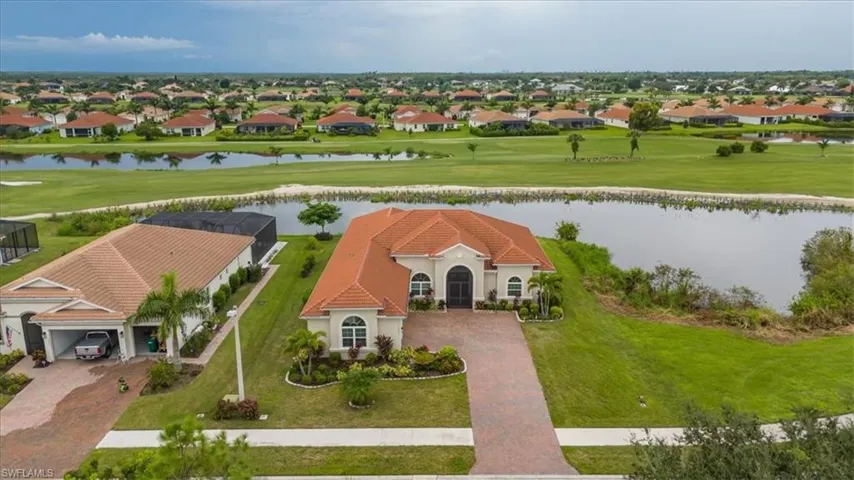 Aerial perspective of suburban area featuring a large body of water and a golf course