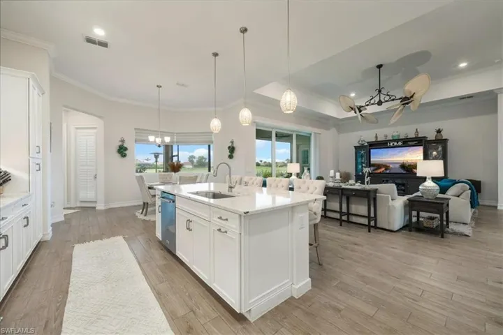 Kitchen with a chandelier, white cabinets, recessed lighting, decorative light fixtures, and a kitchen island with sink