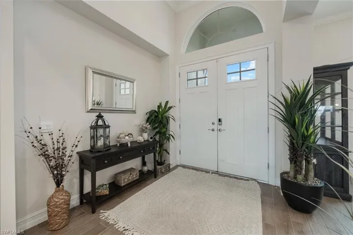 Foyer entrance featuring crown molding and wood finished floors