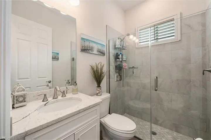 Full bathroom with vanity and a shower stall