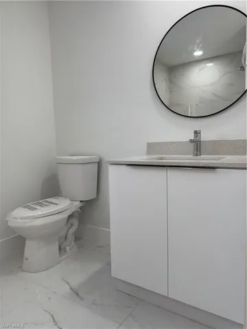 Bathroom with vanity and light marble finish floors