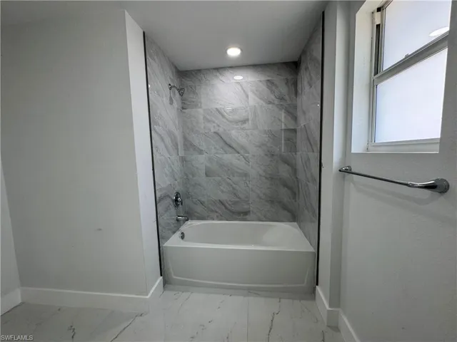 Full bathroom featuring shower / bathtub combination, recessed lighting, and light marble finish floors