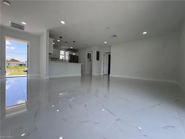 Unfurnished living room featuring recessed lighting and light marble finish floors
