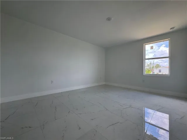 Empty room featuring baseboards and light marble finish floors