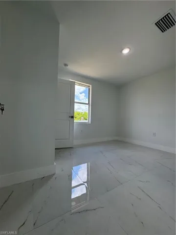 Unfurnished room featuring baseboards and light marble finish flooring
