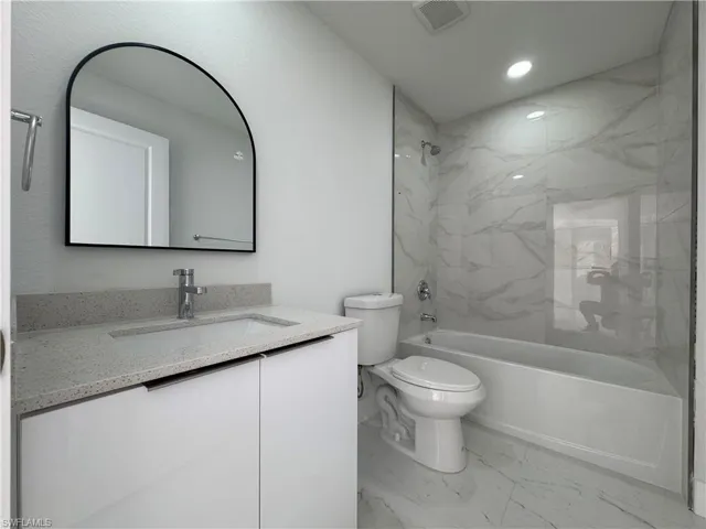 Full bathroom with vanity, light marble finish flooring, bathtub / shower combination, and recessed lighting