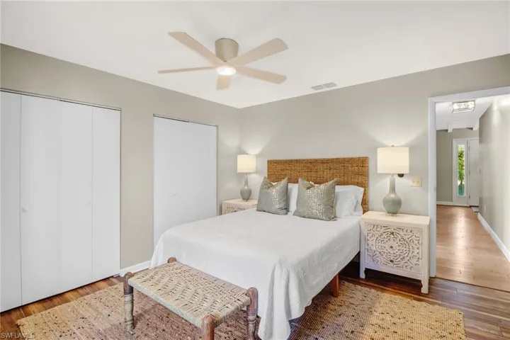Bedroom featuring wood finished floors, a ceiling fan, and two closets