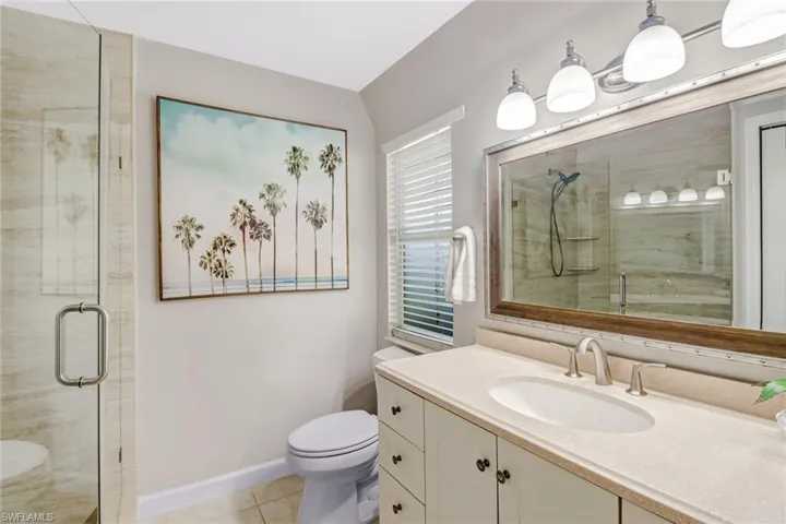 Bathroom with a stall shower, vanity, and tile patterned flooring