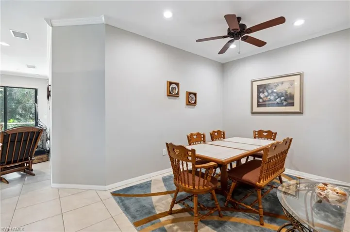 Dining space featuring crown molding, light tile patterned flooring, and ceiling fan
