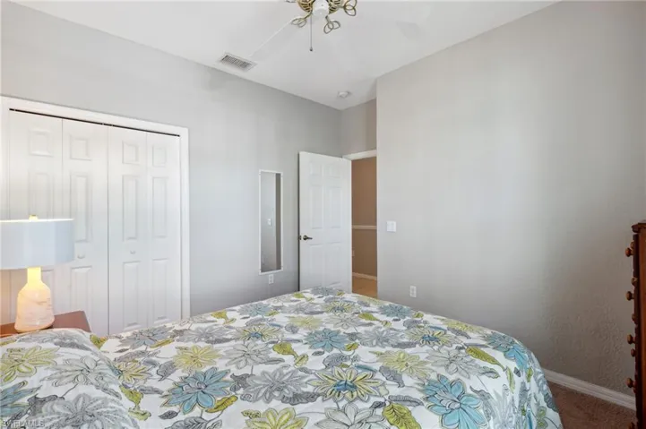 Bedroom featuring carpet flooring, ceiling fan, and a closet