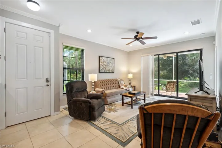 Living room featuring ornamental molding, a wealth of natural light, ceiling fan, and light tile patterned floors