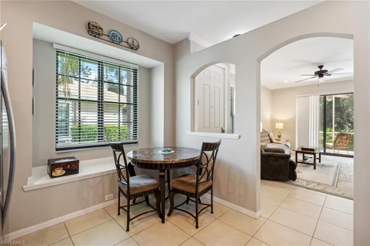 Tiled dining space with crown molding, ceiling fan, and a wealth of natural light