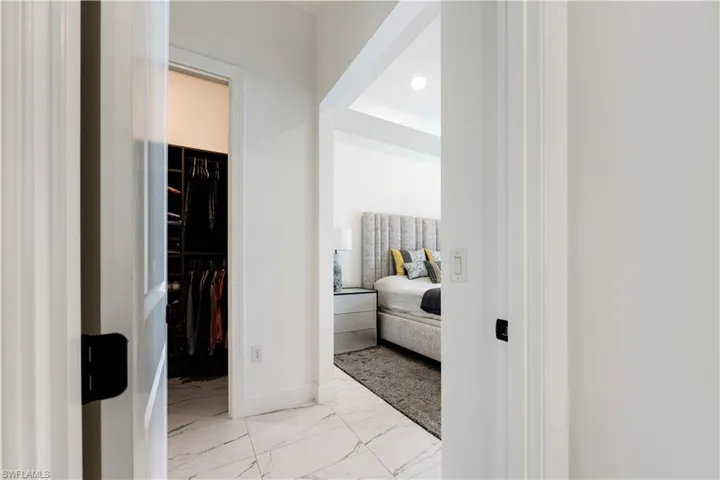 Hallway with white walls and marble-look flooring
