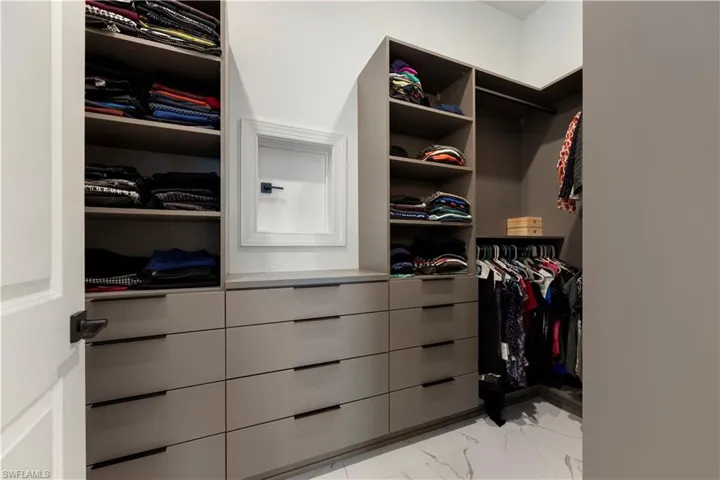 Custom closet system featuring built-in shelving, multiple drawers with linear pulls, and hanging rods