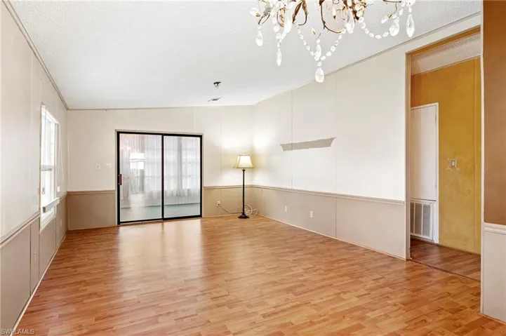 Family room featuring a textured ceiling, light wood-type flooring, and a chandelier