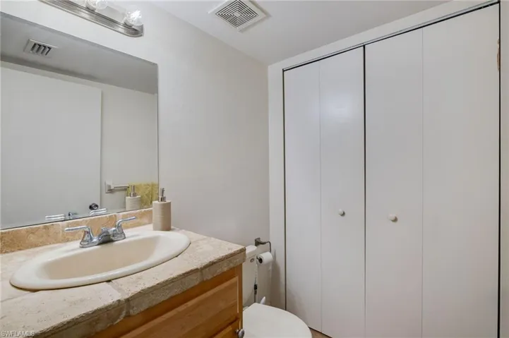 Bathroom vanity with an oval sink, chrome faucet, and a stone-finish countertop