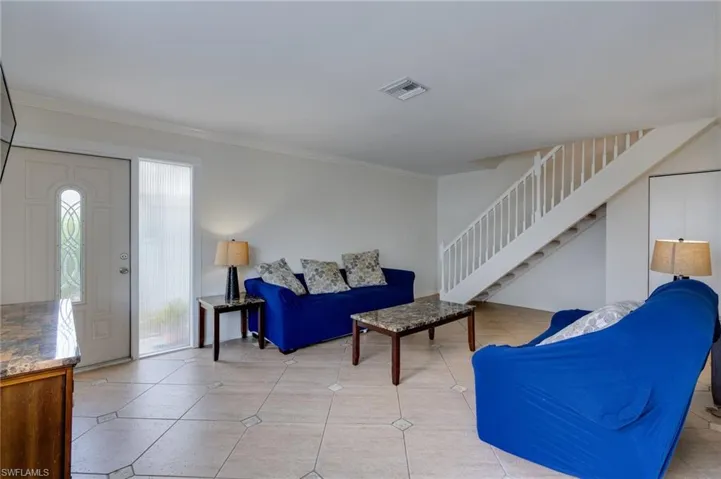 Light-toned tile flooring with decorative inserts throughout the living area