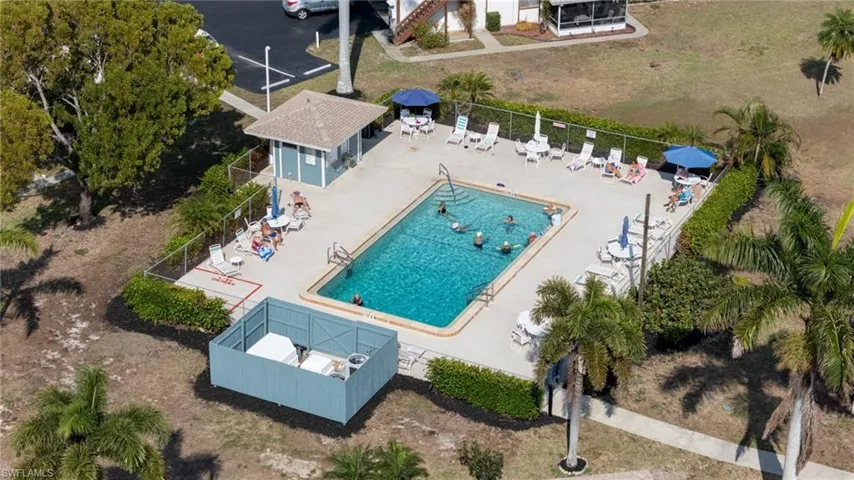 Community swimming pool featuring a rectangular design, surrounding concrete deck, and a dedicated pool house