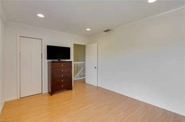 Light wood-finish flooring complements white walls and crown molding