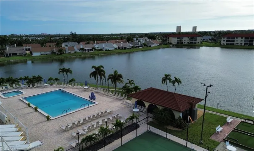 Community pool featuring a water view, a residential view, and a patio area