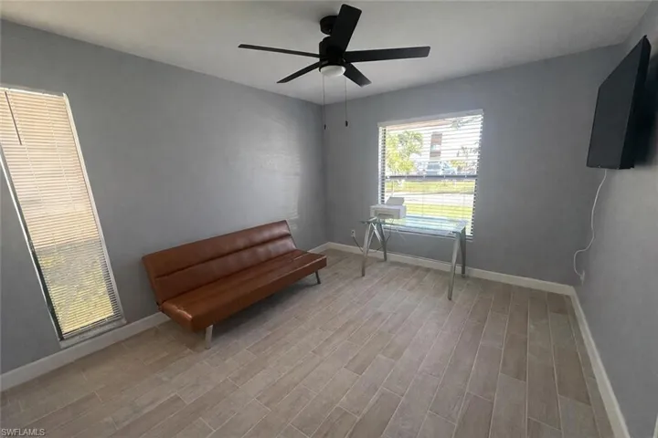 Living area with light wood-style flooring and ceiling fan