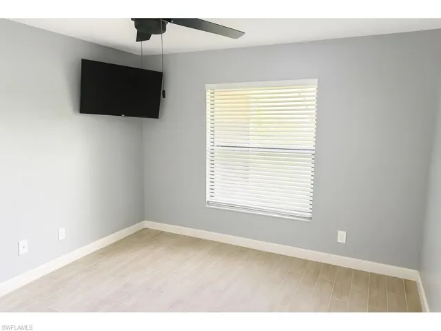 Unfurnished room featuring wood tiled floors and a ceiling fan